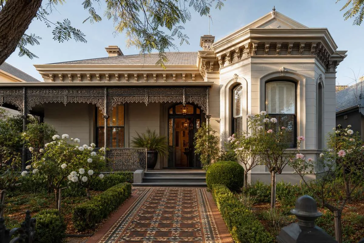 Victorian-era heritage home in Melbourne with ornate lacework verandah and tessellated tile path