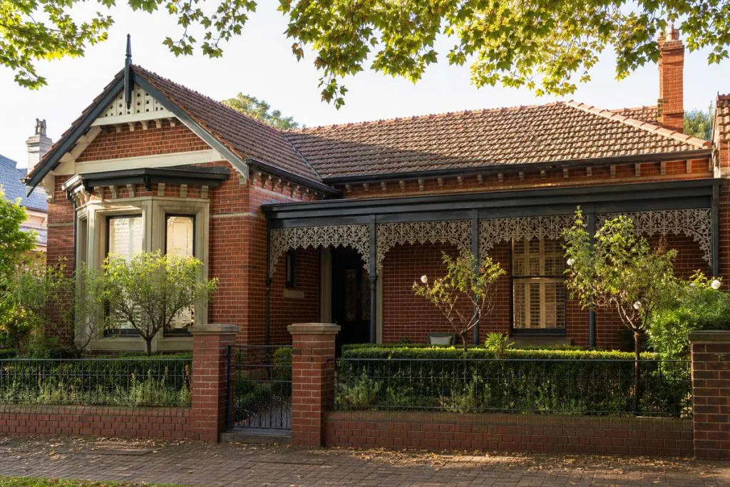 Restored Federation period home facade with cast-iron lacework verandah and tuckpointed brickwork in Melbourne inner suburb